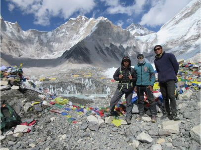 climbers and a sherpa standing at basecamp